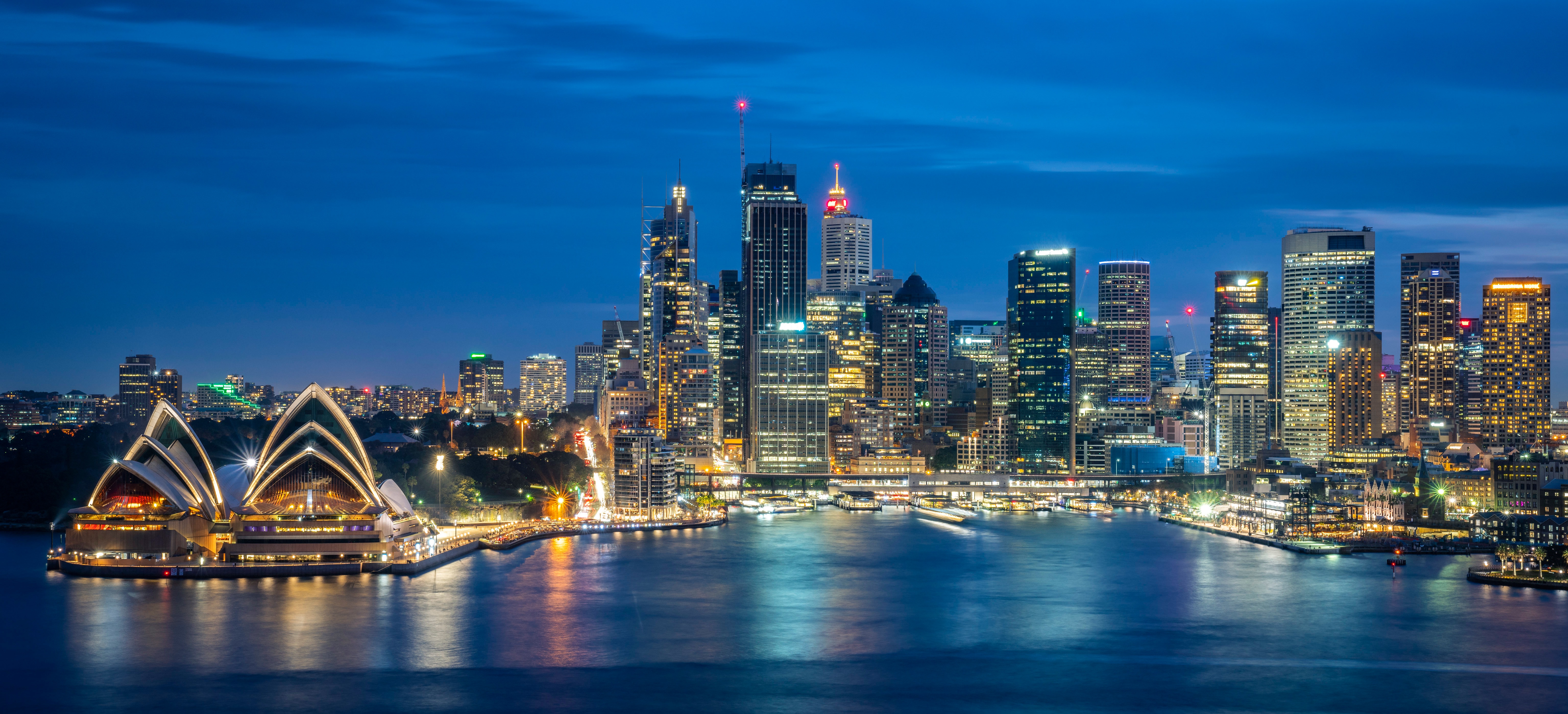 Sydney Opera House and city skyline lit up at night on Sydney Harbour