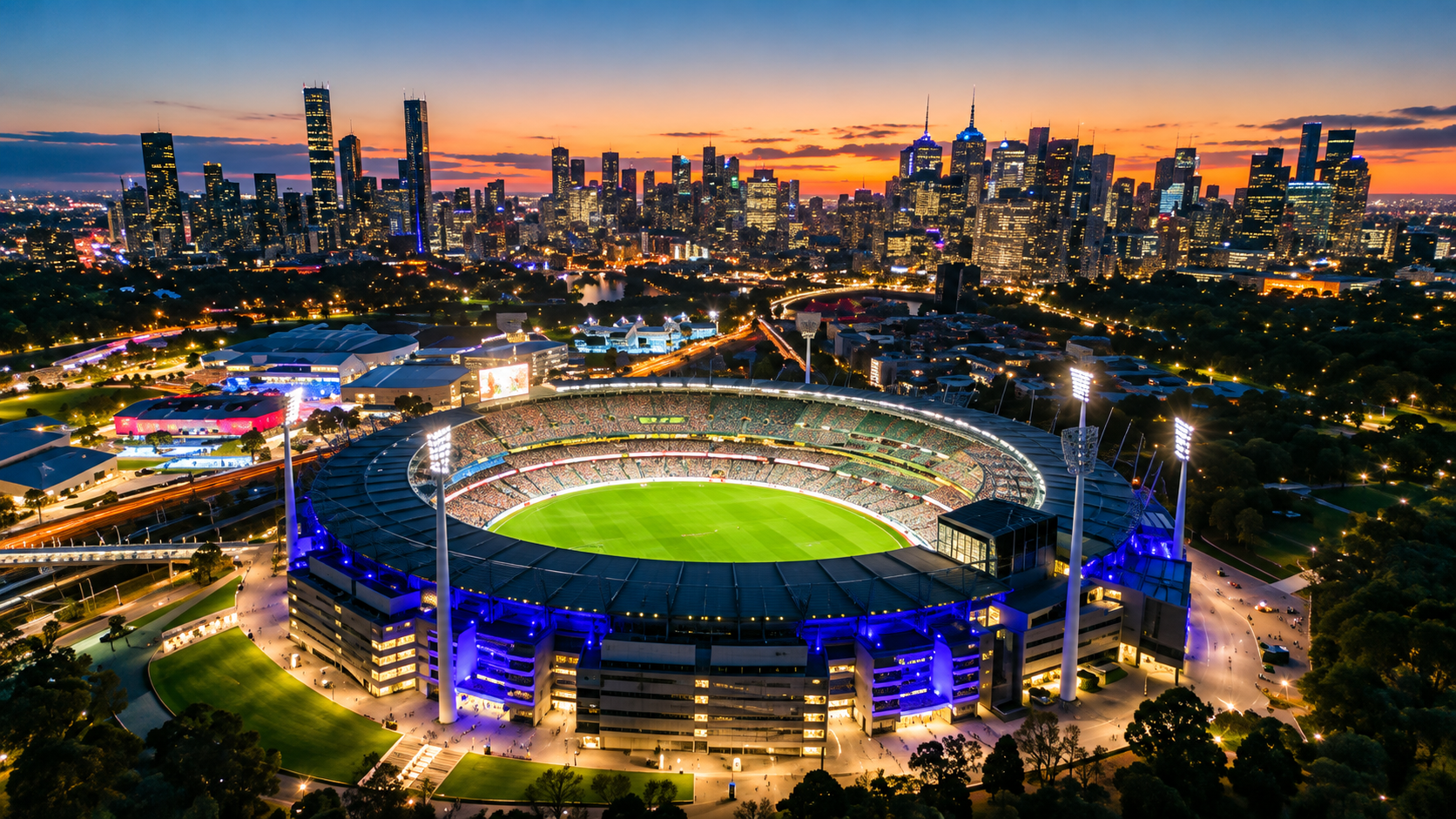 Melbourne Cricket Ground lit up at dusk against the city skyline